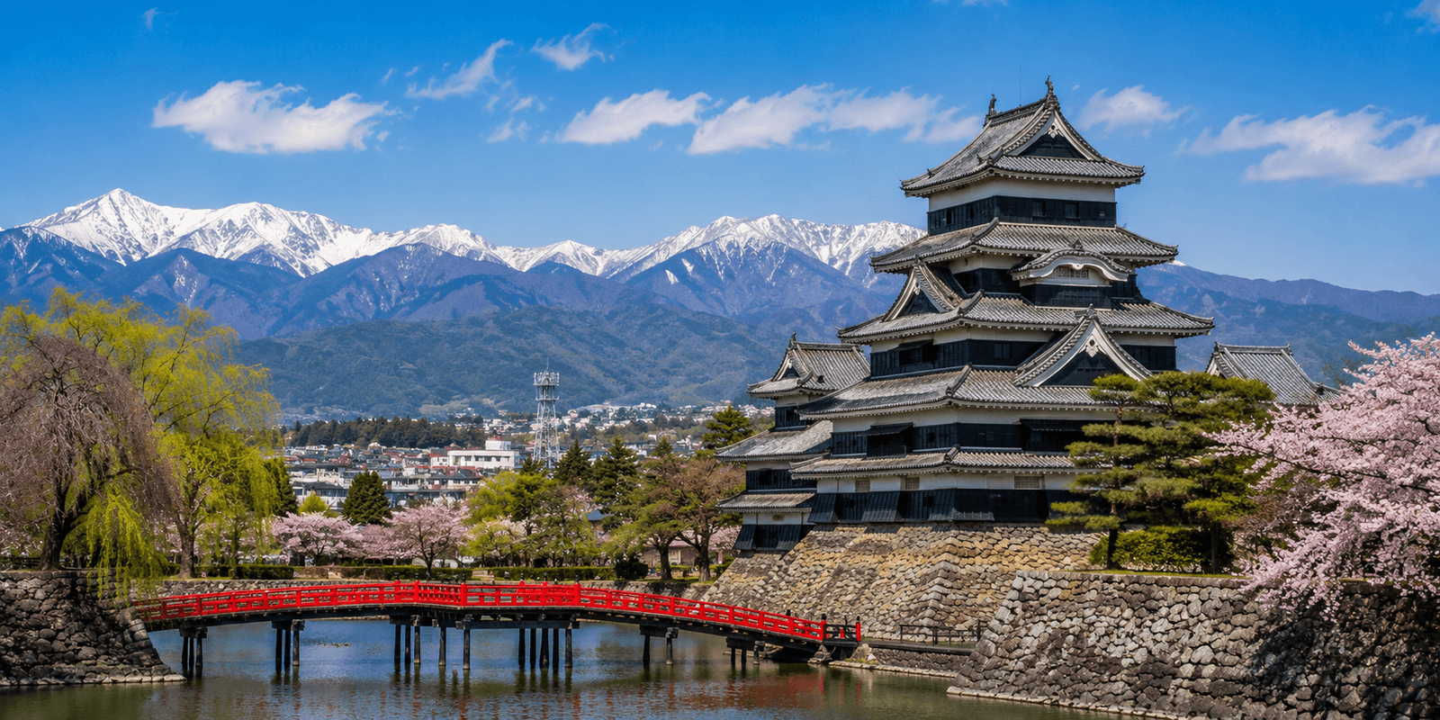 The black and white keep of Matsumoto Castle reflected in its moat, with the snow-capped Northern Japan Alps behind