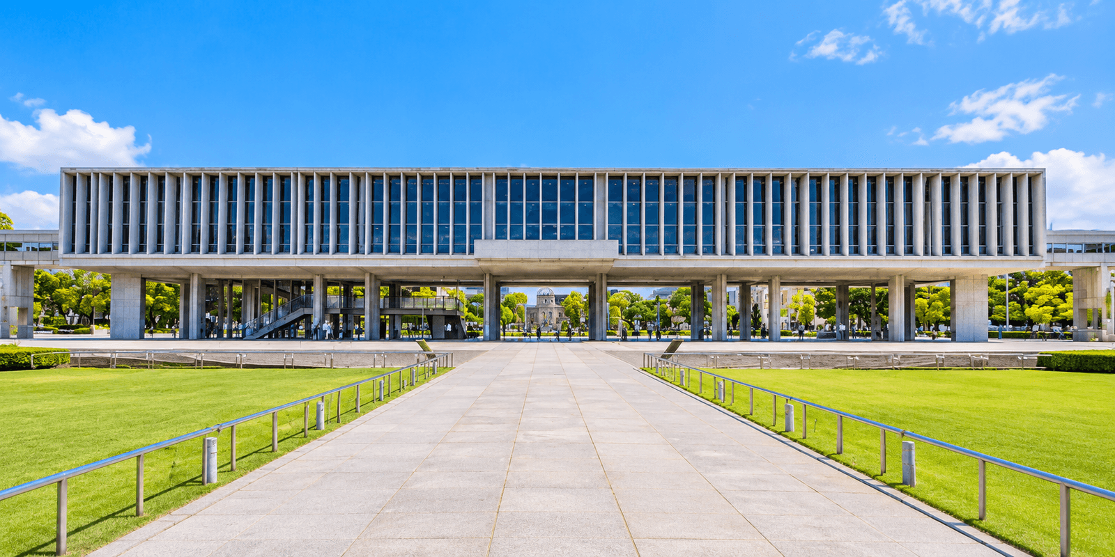 Hiroshima Peace Memorial Museum Main Building raised on pillars, with the Atomic Bomb Dome visible through the central opening