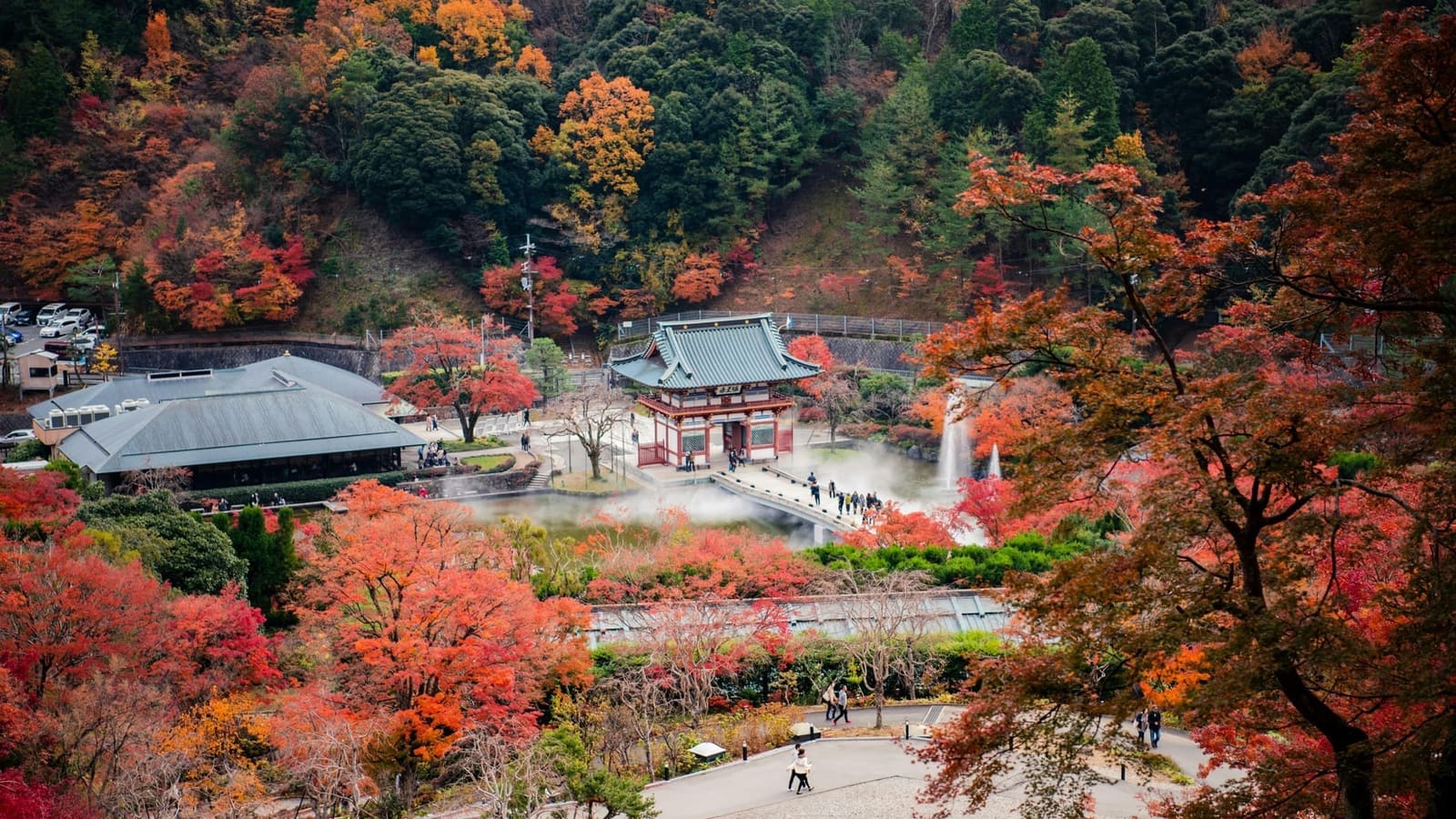 Minoo Park forest trail with autumn foliage and the Minoo waterfall visible through the trees, Osaka Prefecture Japan