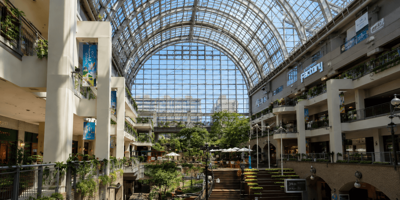 The glass atrium and historic brick buildings of Sapporo Factory shopping complex