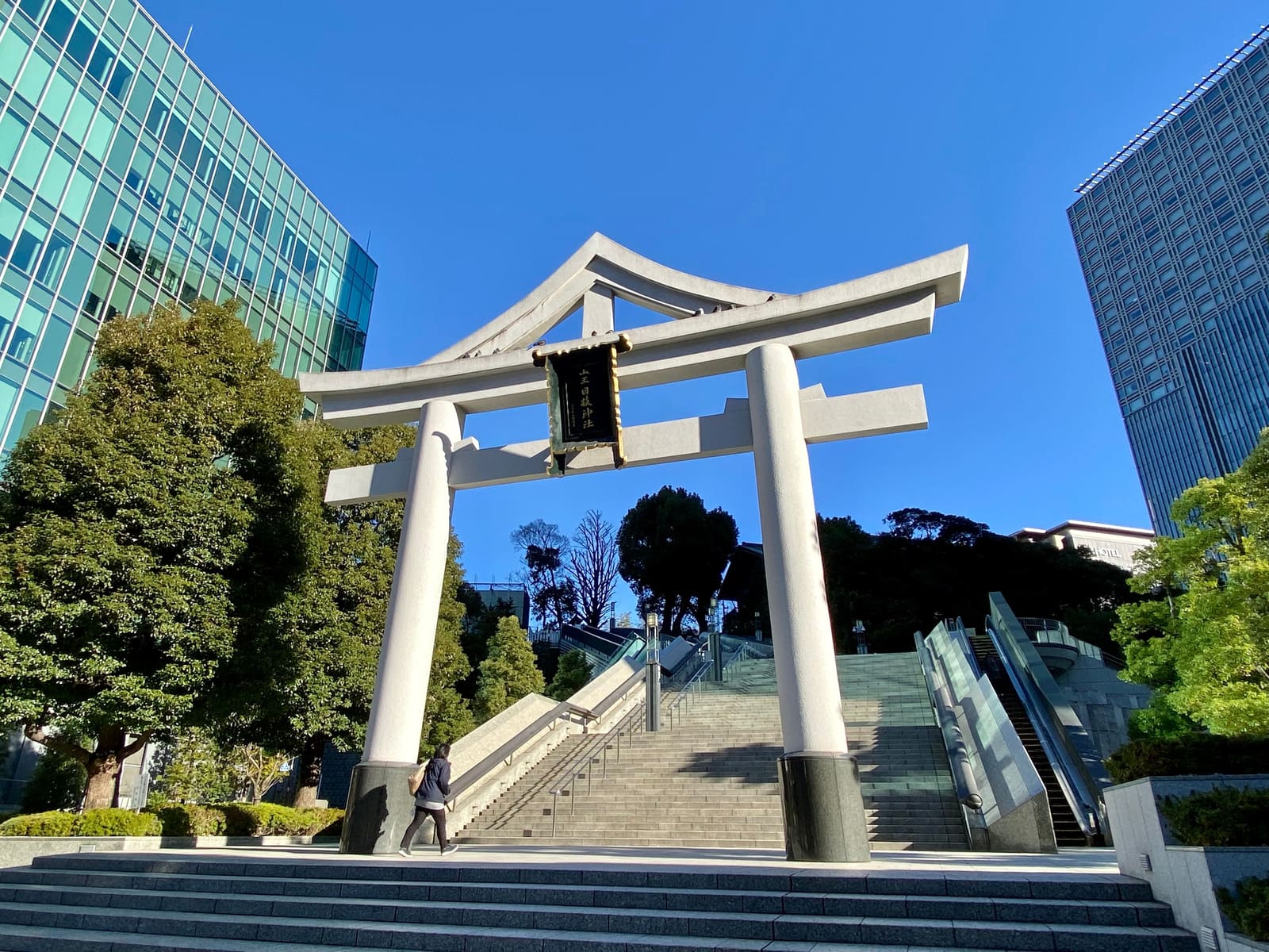 Zojo-ji Temple with Tokyo Tower rising prominently behind it against a clear blue sky