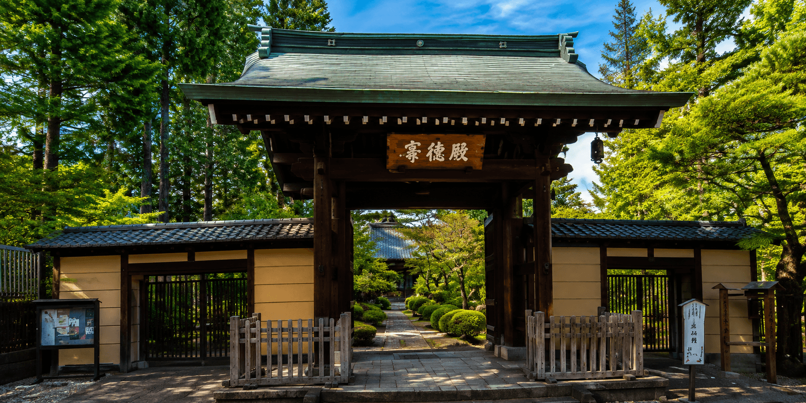 Gotokuji Temple's wooden entrance gate leading into the tree-lined temple grounds, Setagaya, Tokyo, Japan