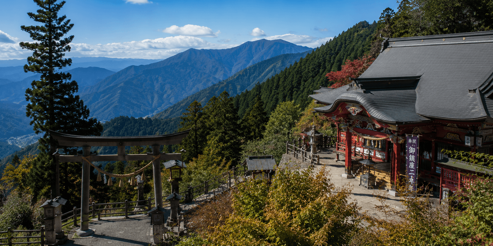 Musashi Mitake Shrine's wooden torii gate and vermillion summit building on Mount Mitake, overlooking layered mountain ridges in Ome, western Tokyo, Japan