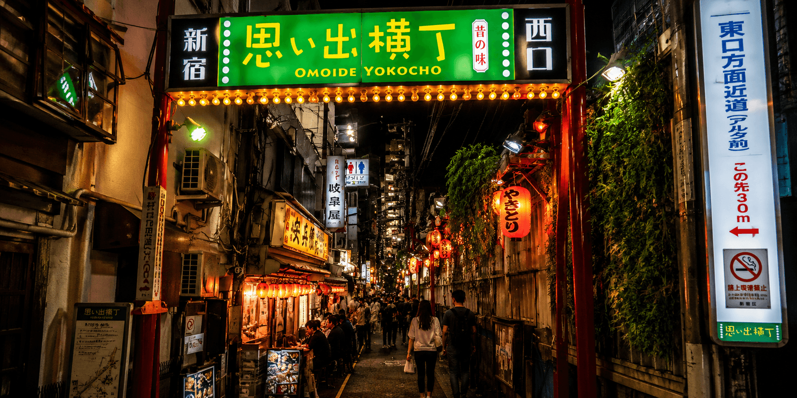 Omoide Yokocho's narrow lantern-lit alley with glowing red lanterns and small yakitori restaurant counters, Shinjuku, Tokyo, Japan