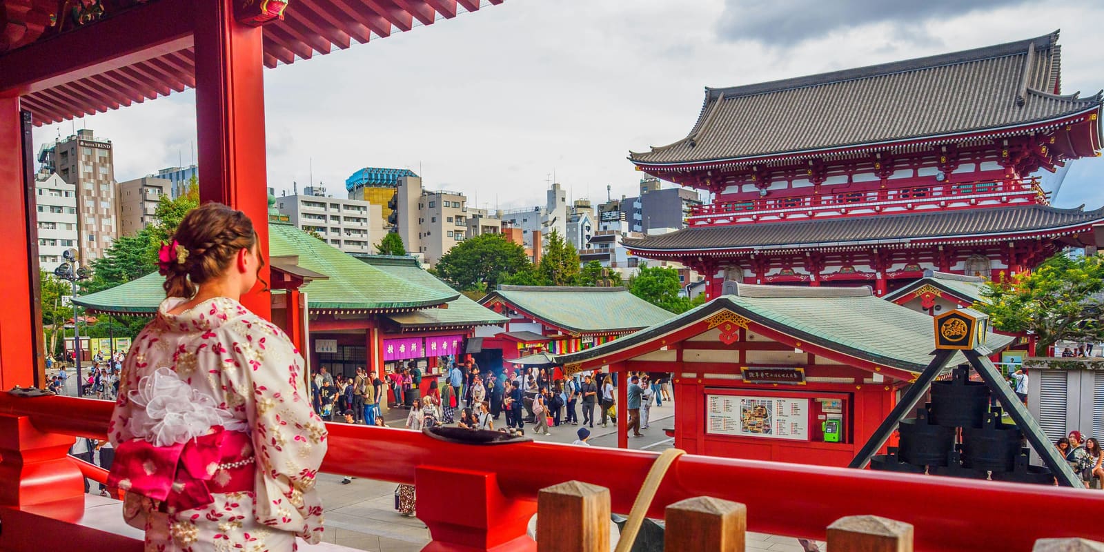 A visitor in a kimono overlooking the busy grounds of Senso-ji Temple in Asakusa