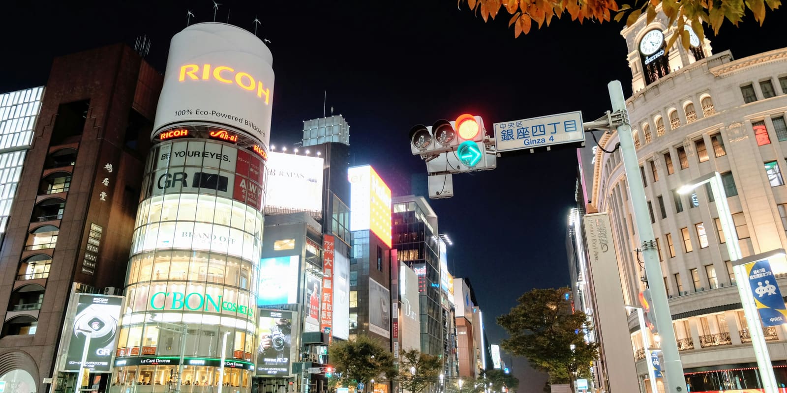 The Ginza 4-chome crossing at night, with the illuminated Ricoh tower and the Wako clock tower