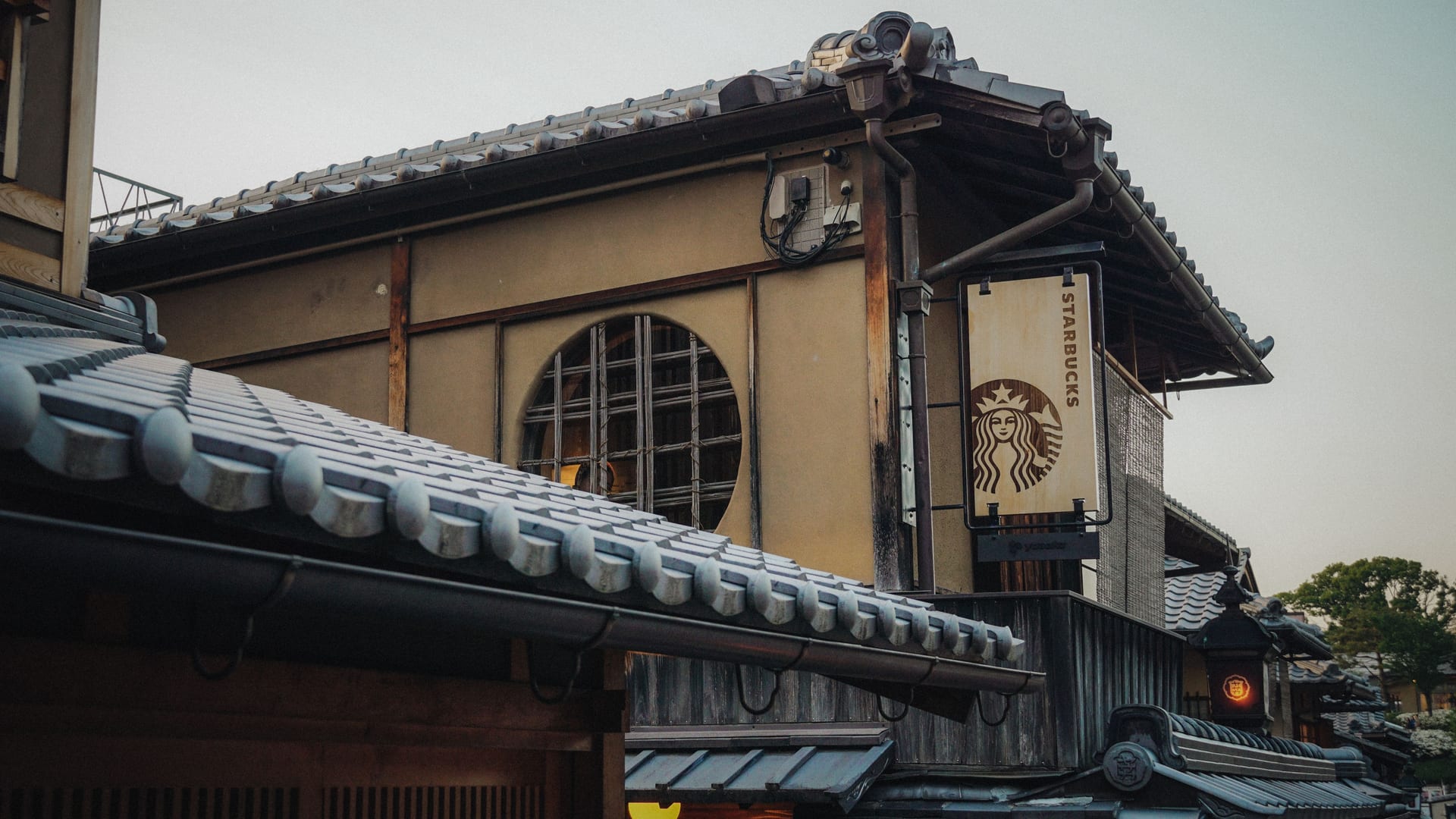 Narrow stone-paved alley with lanterns and machiya townhouses in the Gion district of Kyoto at dusk