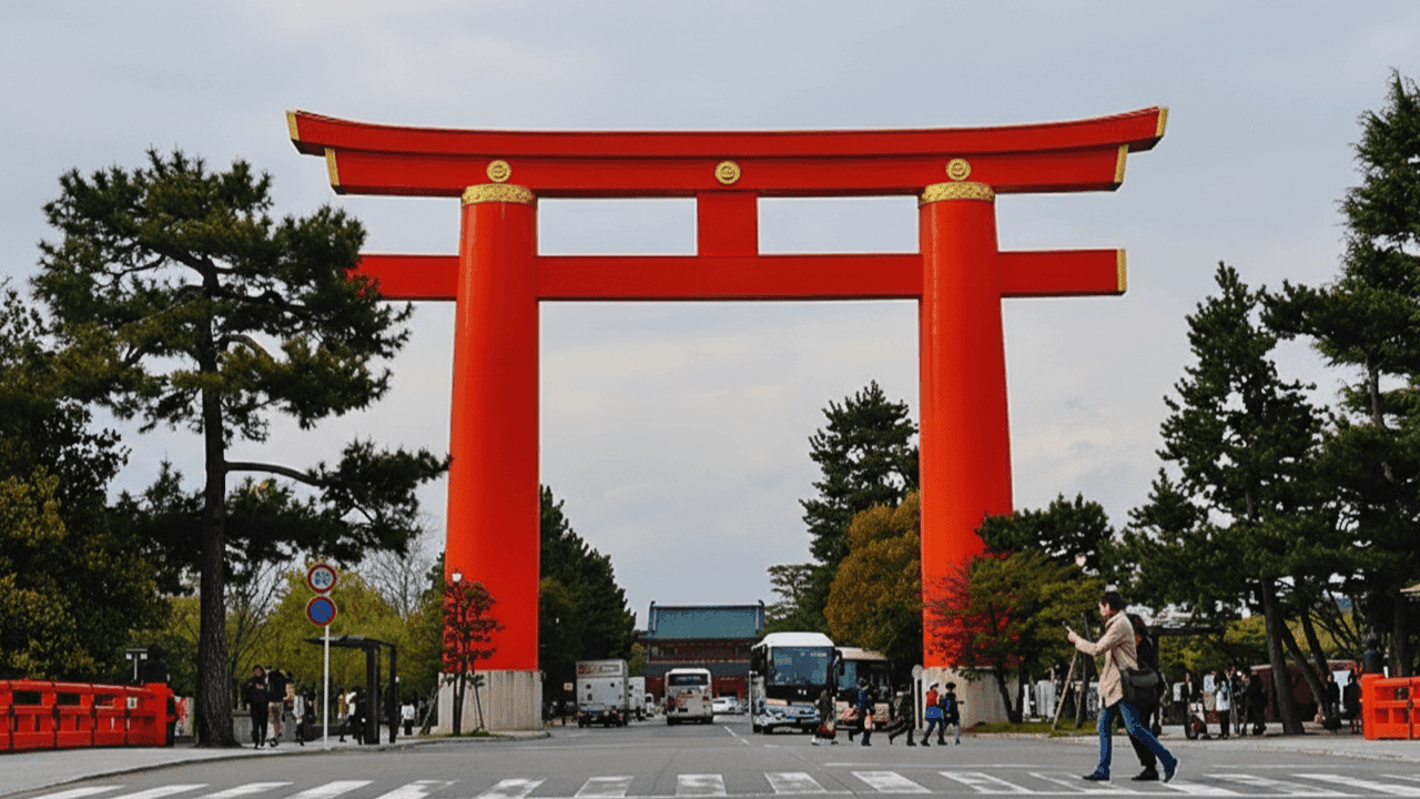 Heian Shrine large vermilion torii gate and bright orange shrine buildings in the Okazaki district with mountains behind, Kyoto