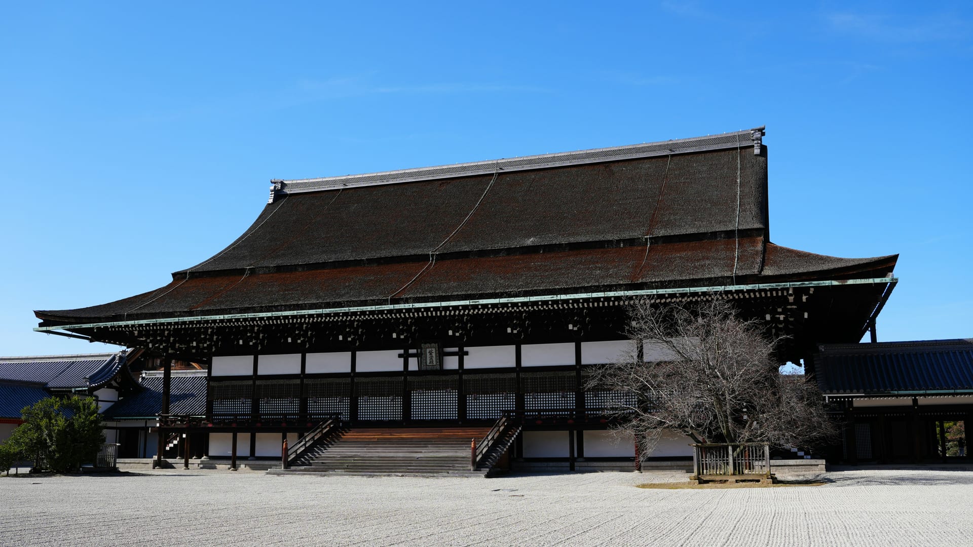 Kyoto Imperial Palace traditional gate and white earthen walls within the green lawns of Kyoto Imperial Park