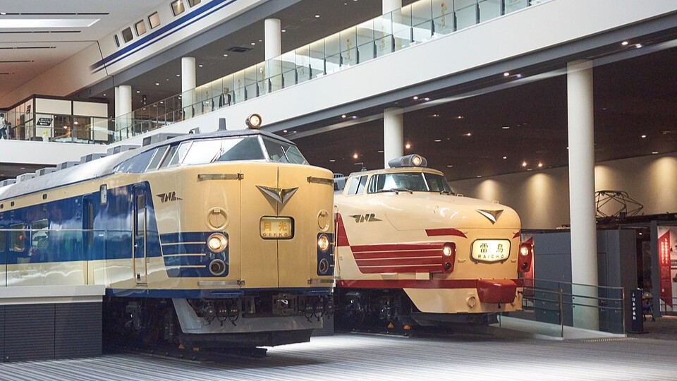 Historic steam locomotives and vintage railway carriages displayed inside the vast Kyoto Railway Museum