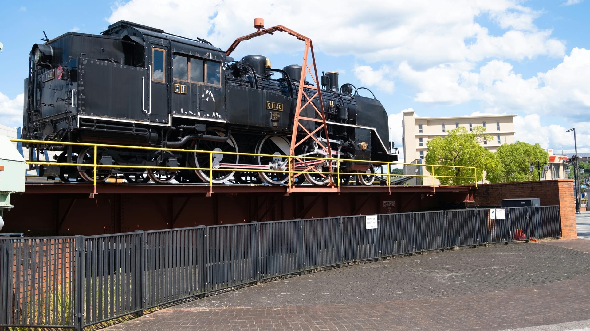 Row of historic steam locomotives and vintage trains displayed inside the Kyoto Railway Museum