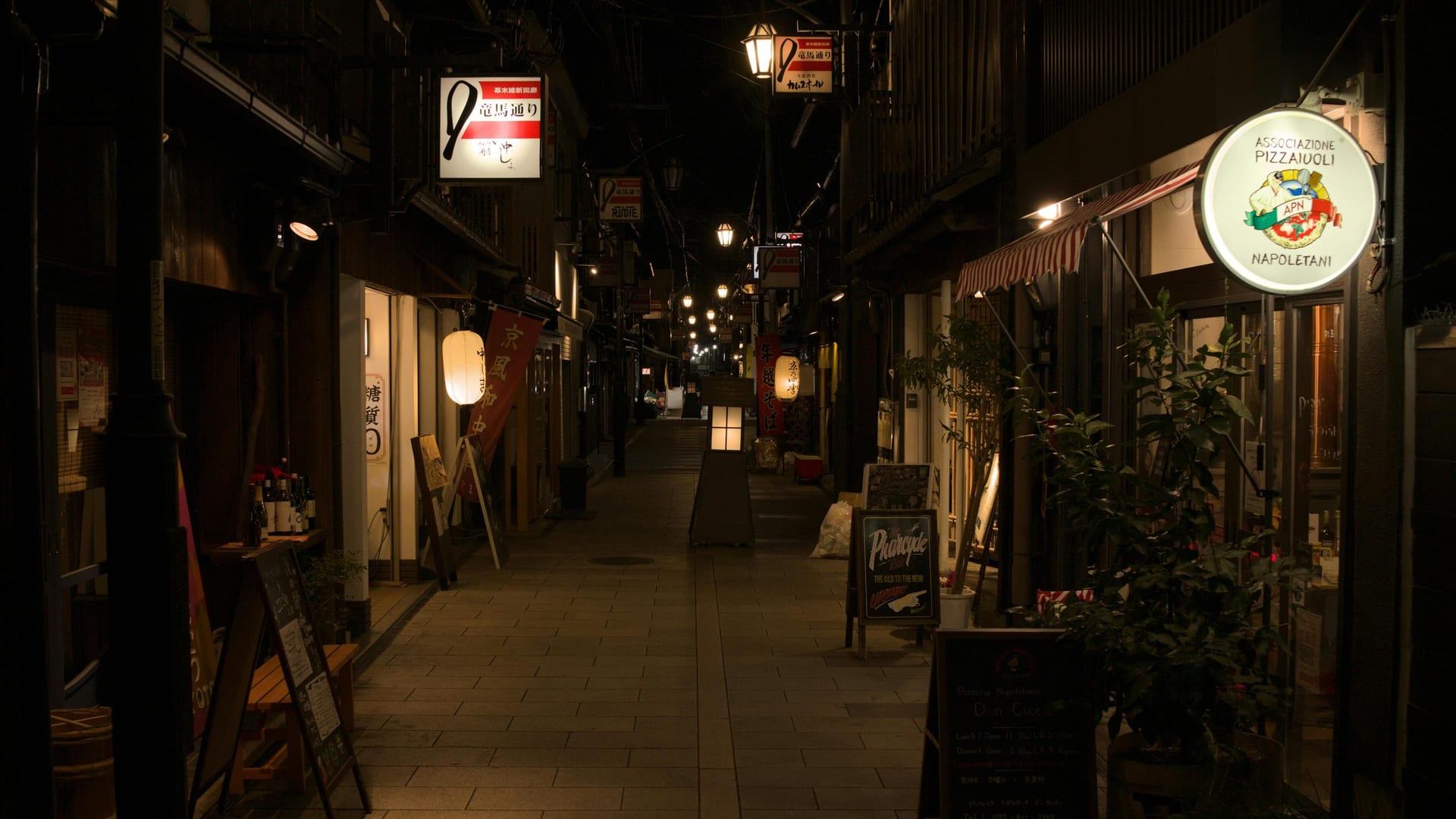 Pontocho Alley narrow lantern-lit passage with restaurant facades glowing alongside the Kamo River at night, Kyoto