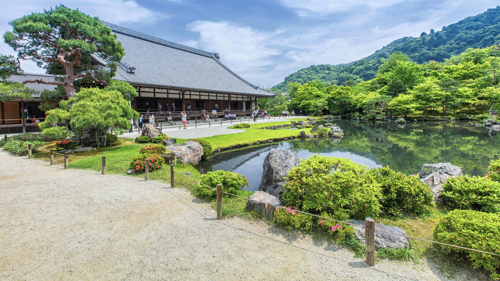 Tenryu-ji Temple Zen garden with the central pond reflecting the shaped pines and the forested Arashiyama hills as borrowed scenery, Kyoto