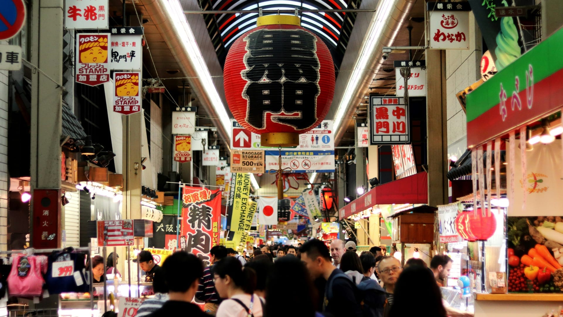 Kuromon Ichiba Market vendors grilling fresh seafood and wagyu skewers at open kitchen counters, Osaka Japan