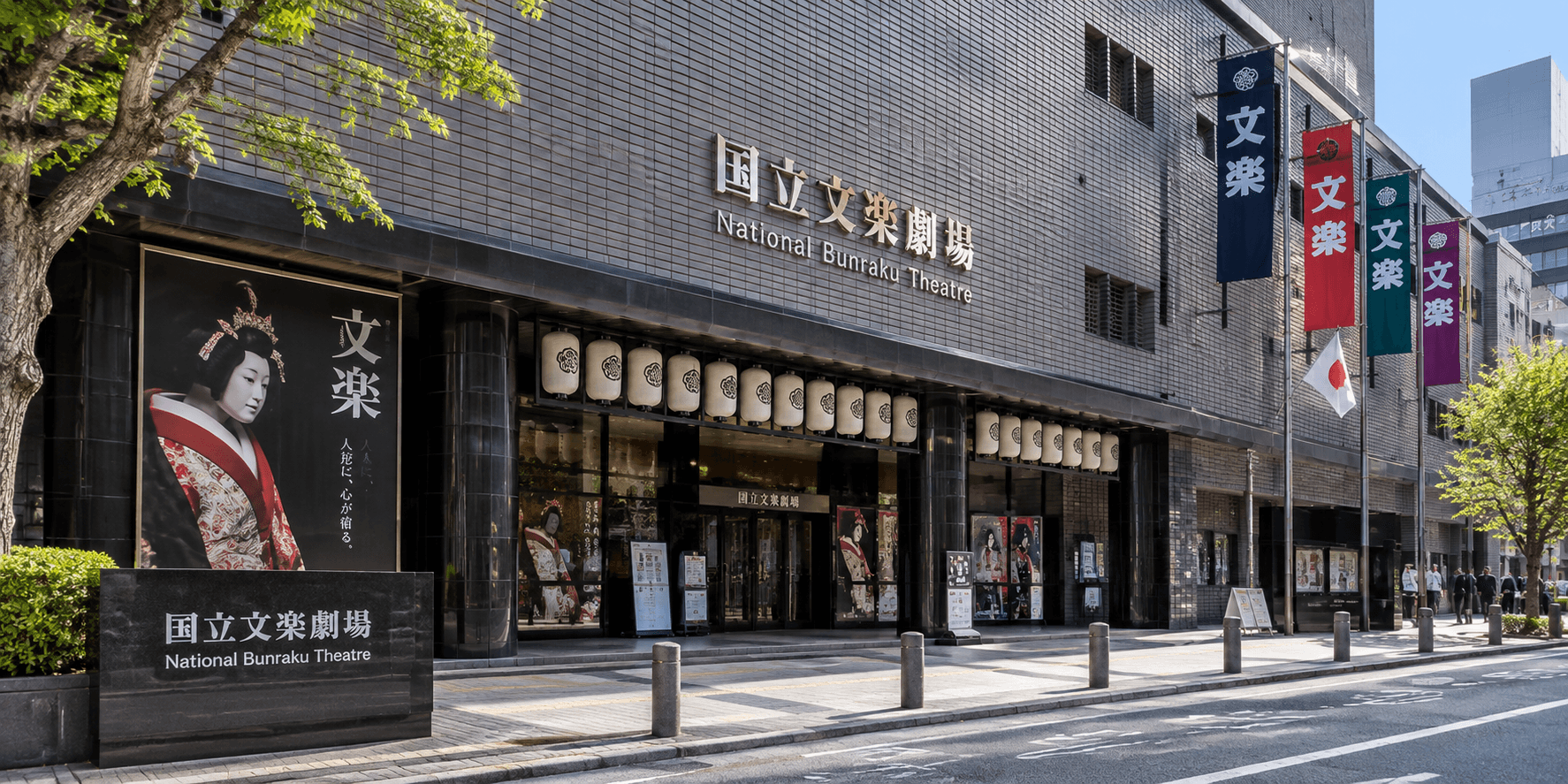 National Bunraku Theatre's entrance facade with bilingual signage and bunraku promotional banners in Nipponbashi, Osaka Japan