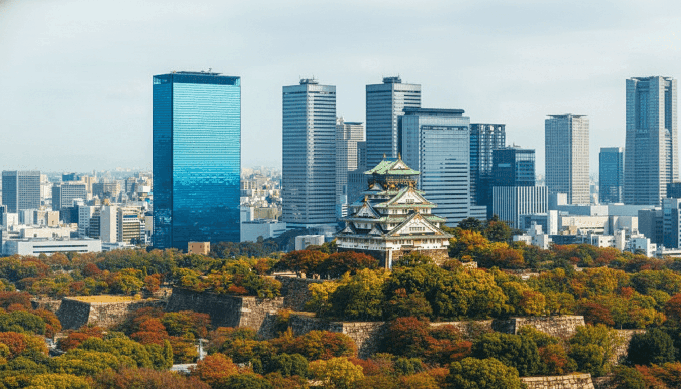 Osaka Castle main tower with white exterior panels and gold decorative details rising above the stone walls, Osaka Japan
