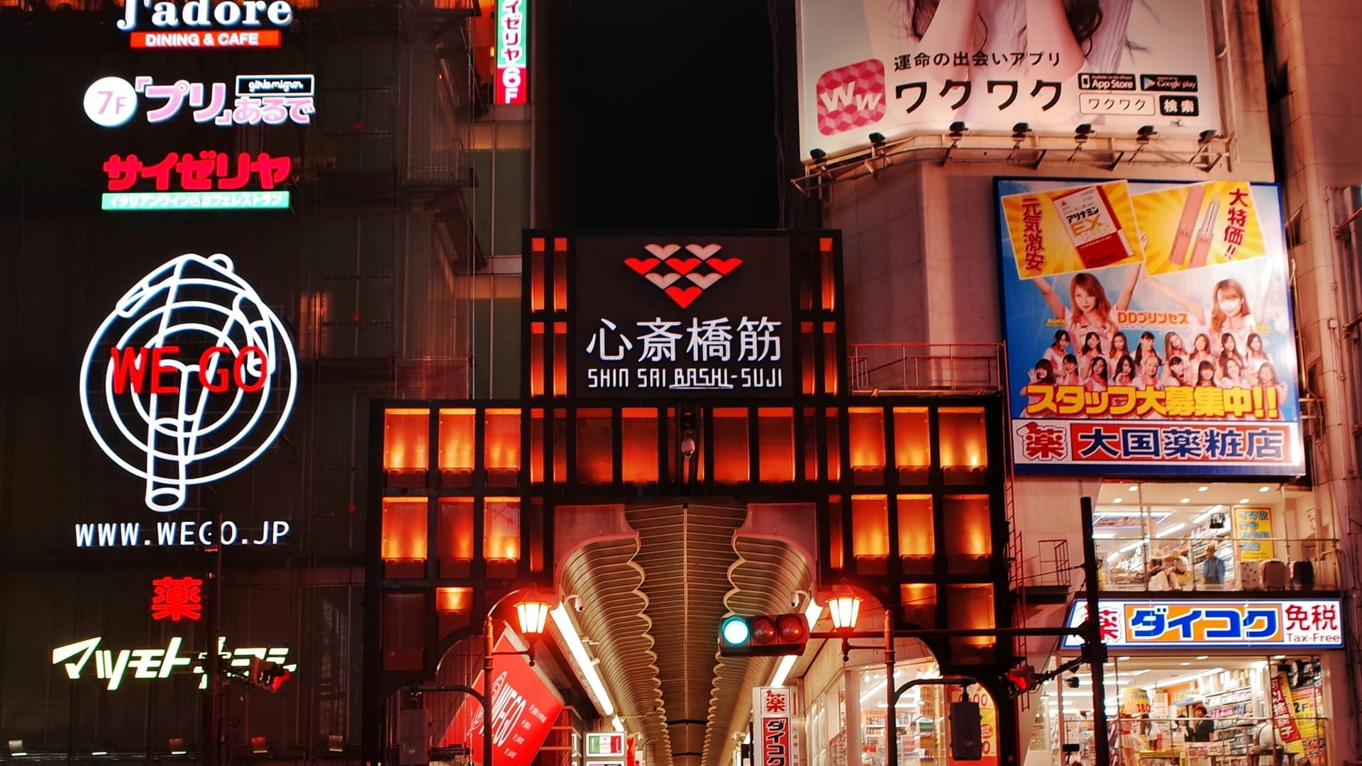 Shinsaibashi Shopping Street covered arcade with glass roof and pedestrians browsing storefronts, Osaka Japan