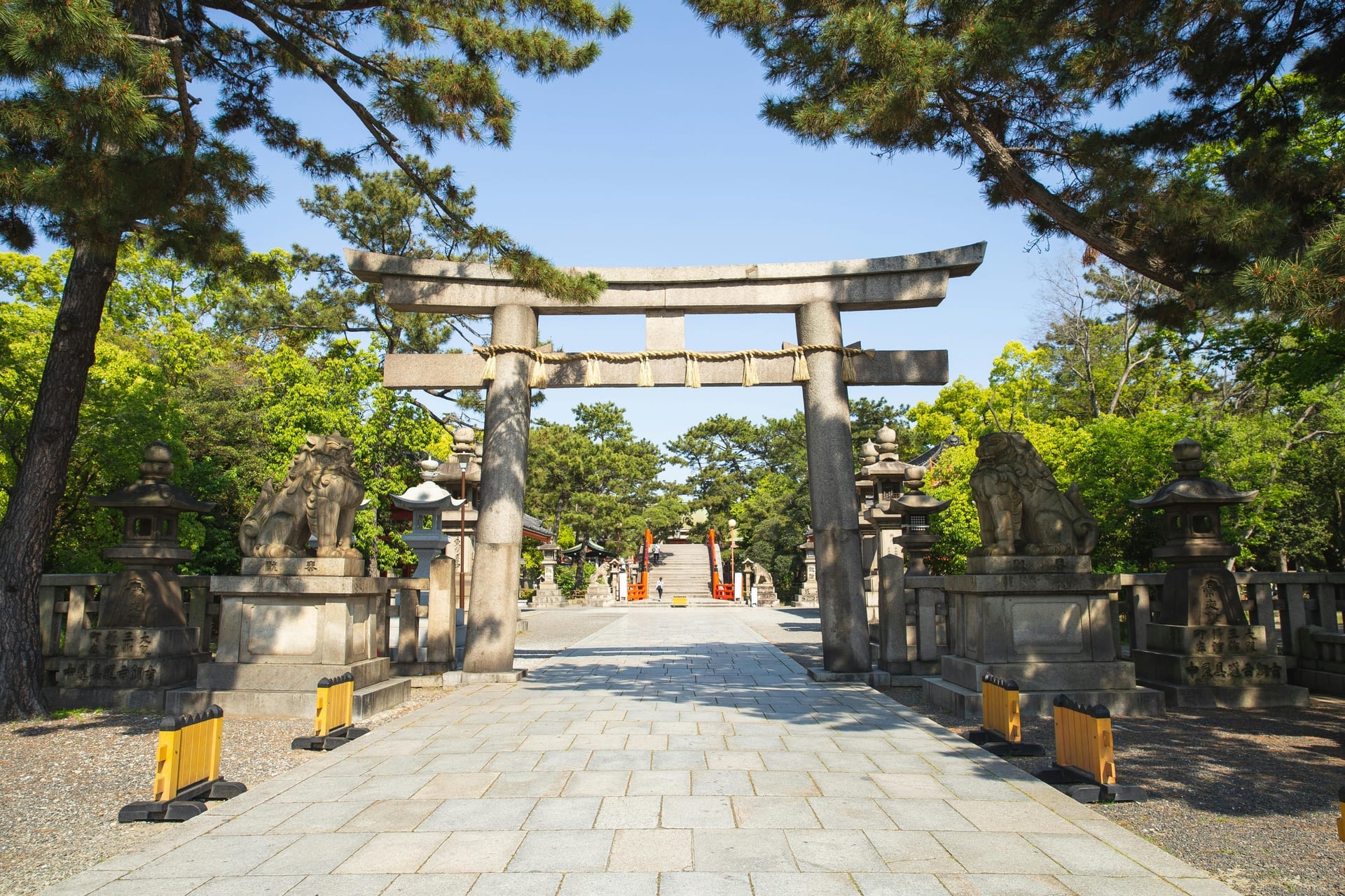 Tree-lined pathways and stone torii gate leading through the grounds of Sumiyoshi Taisha Shrine, Osaka Japan