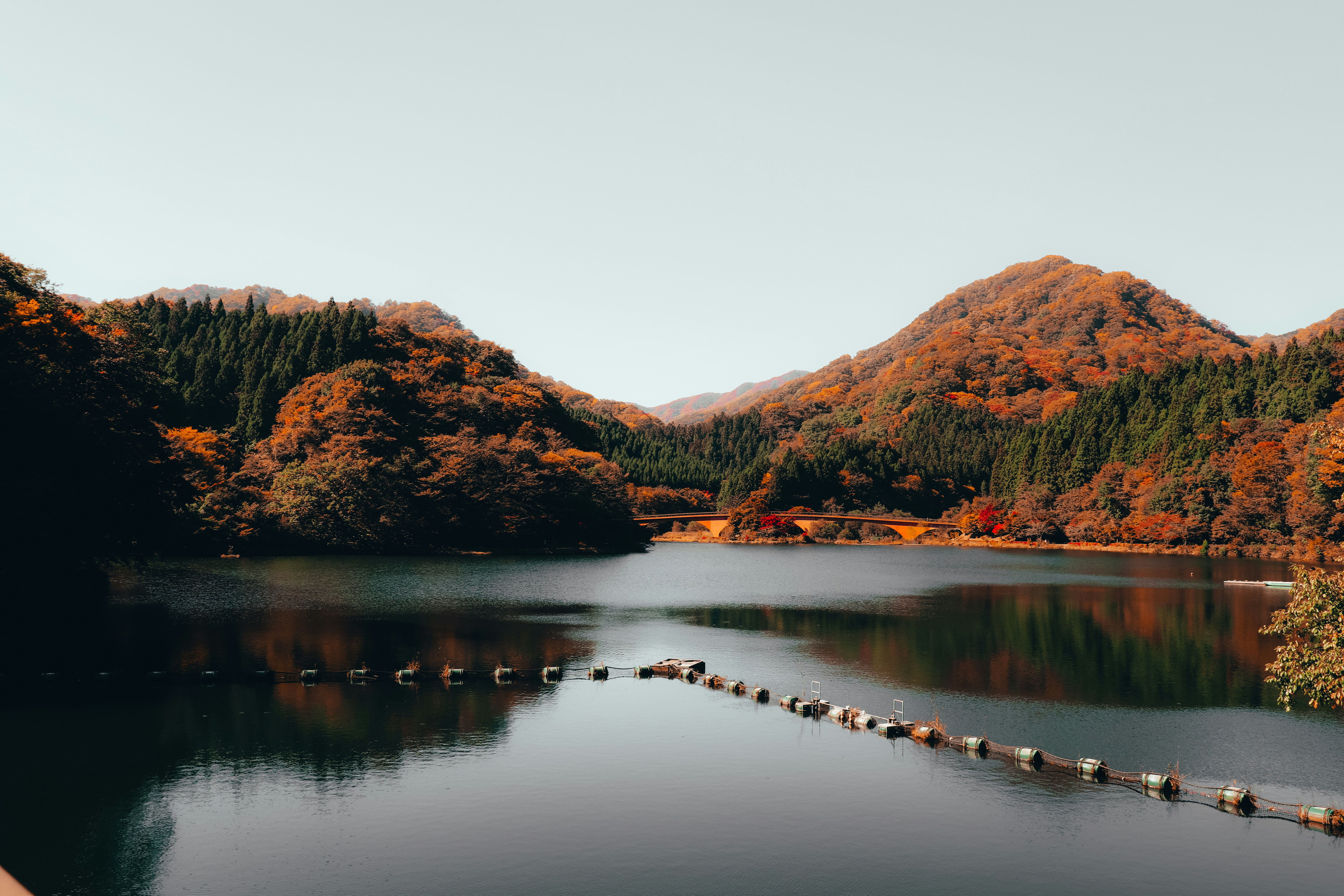 Mountains covered in red and orange autumn foliage reflected in a still lake
