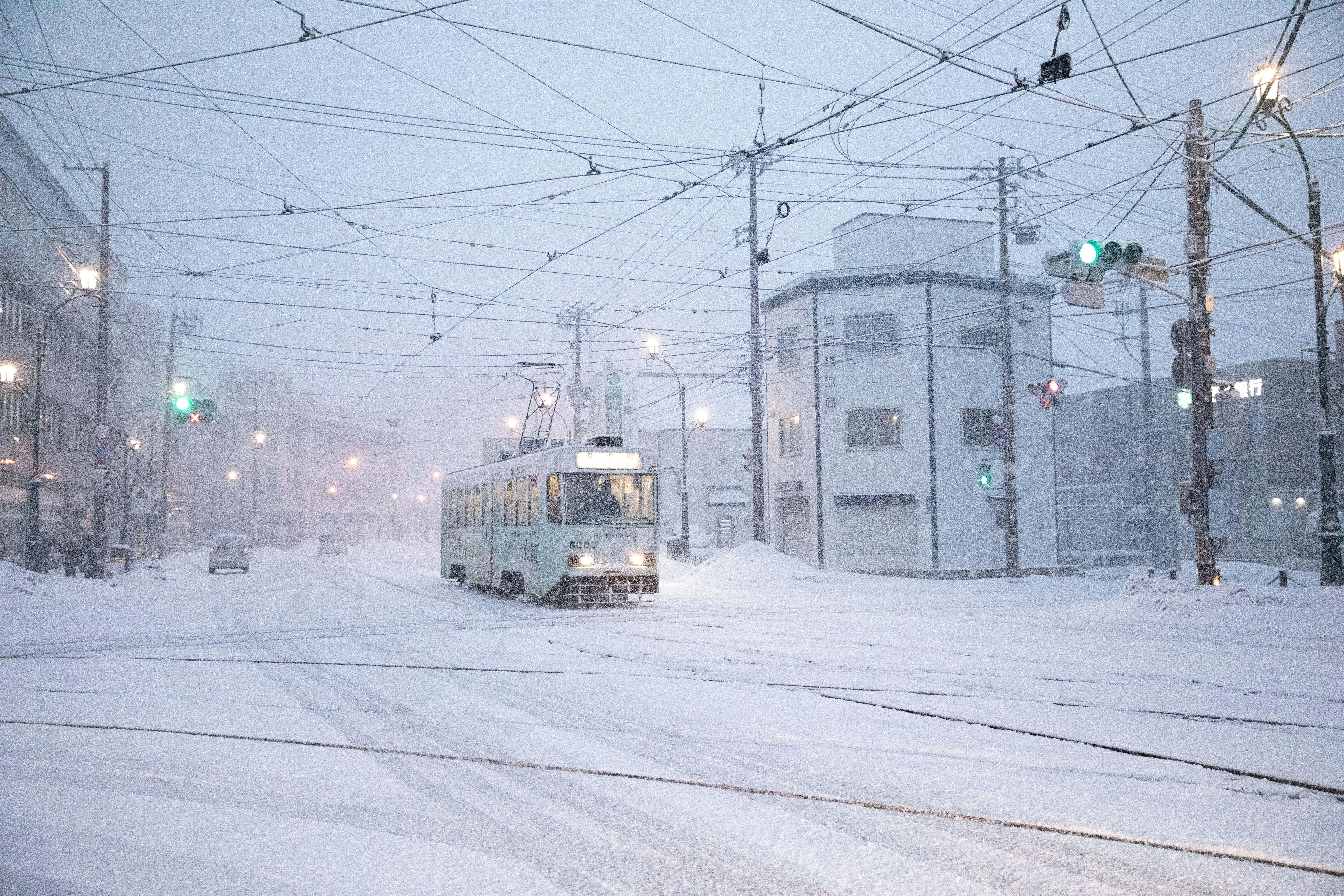 A snow-covered tram making its way through a heavy snowstorm in Sapporo