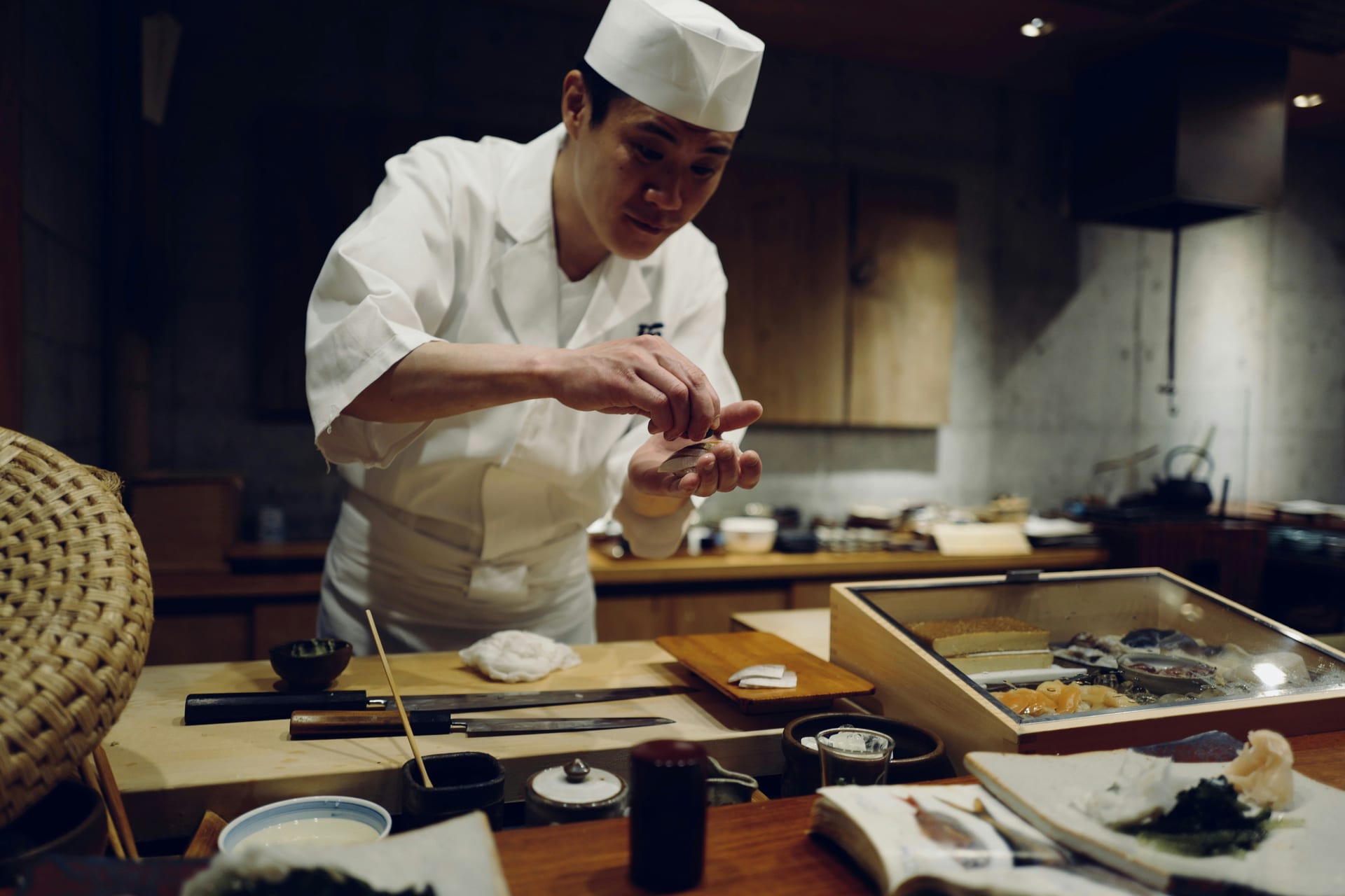 Sushi chef preparing nigiri at a traditional sushi counter