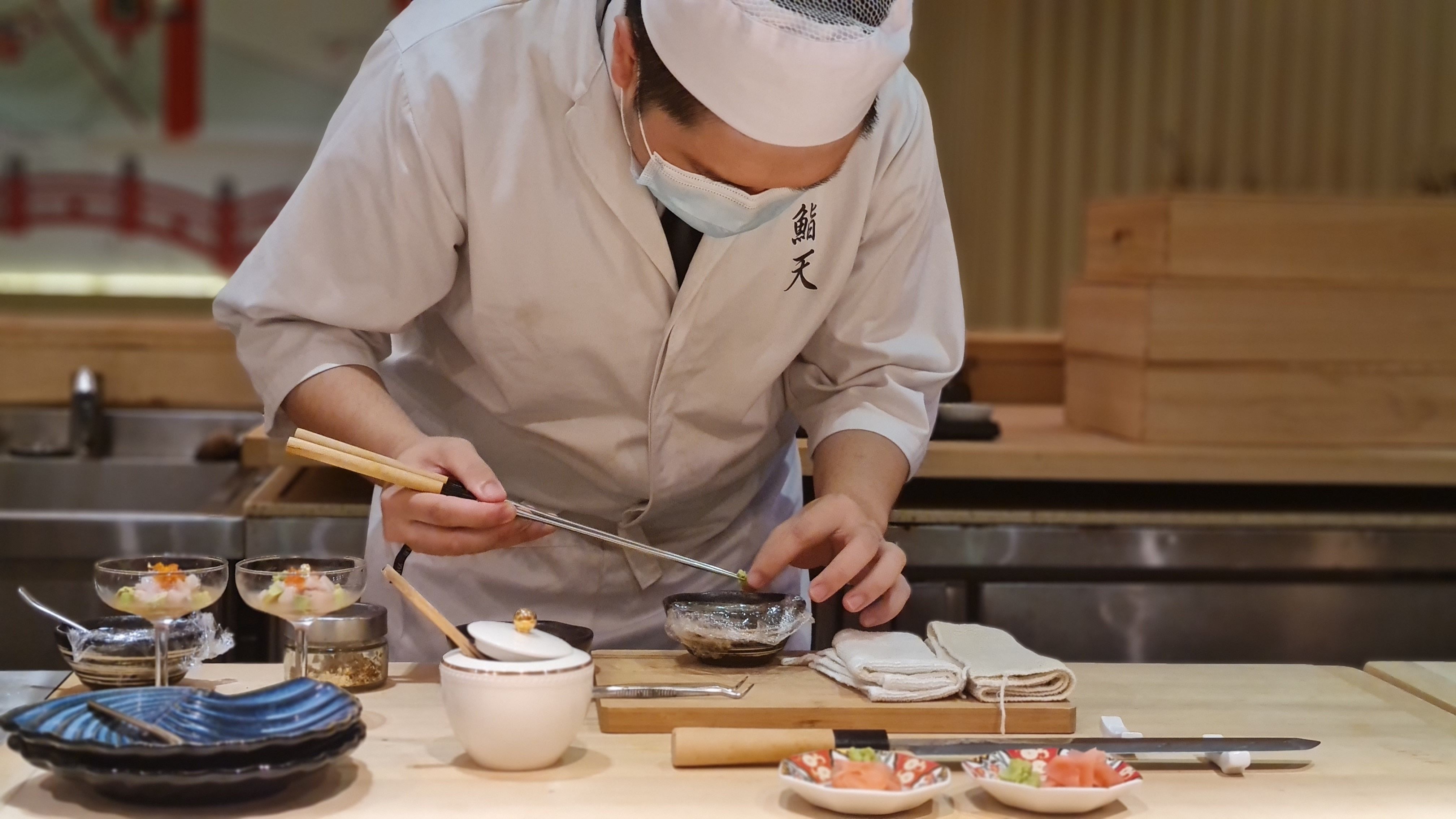 Sushi chef preparing nigiri at a traditional sushi counter